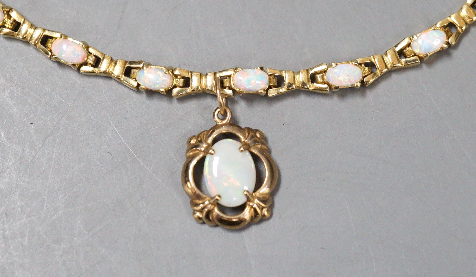 A modern 585 yellow metal and fourteen stone opal set drop bracelet, 19.3cm, gross weight 10.7 rams.